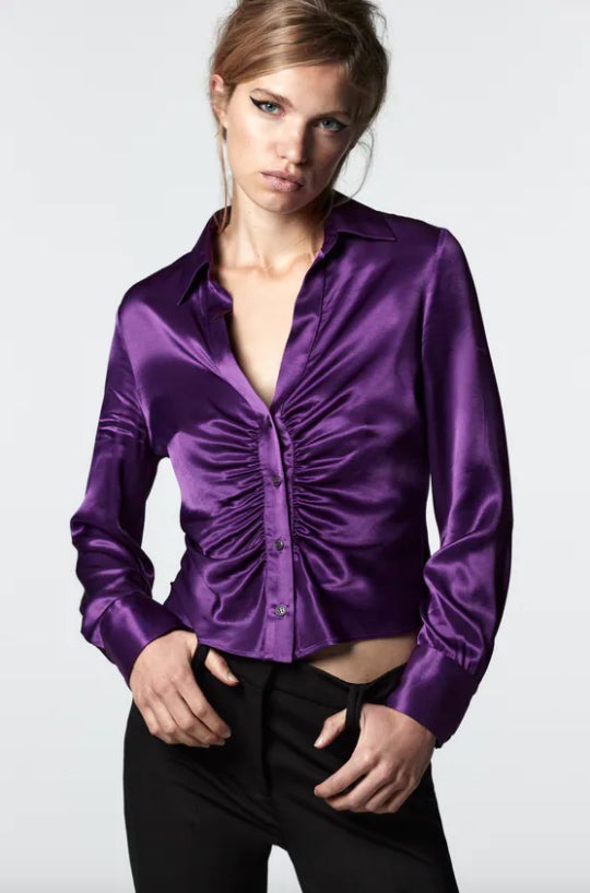 Confeccionada en tejido satinado, con cuello solapa, escote de pico y mangas largas acabadas en puño, esta camisa con detalle de pliegues en delantero y cierre frontal es de Zara y está disponible entre las tallas XS y XXL por 29,95 euros. 