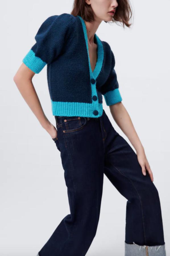 Diseño cropped para este cárdigan de Zara que combina dos tonos de azul, tiene escote de pico, mangas cortas y cierre frontal de botones. Disponible en las tallas S, M y L, cuesta 22,95 euros. 