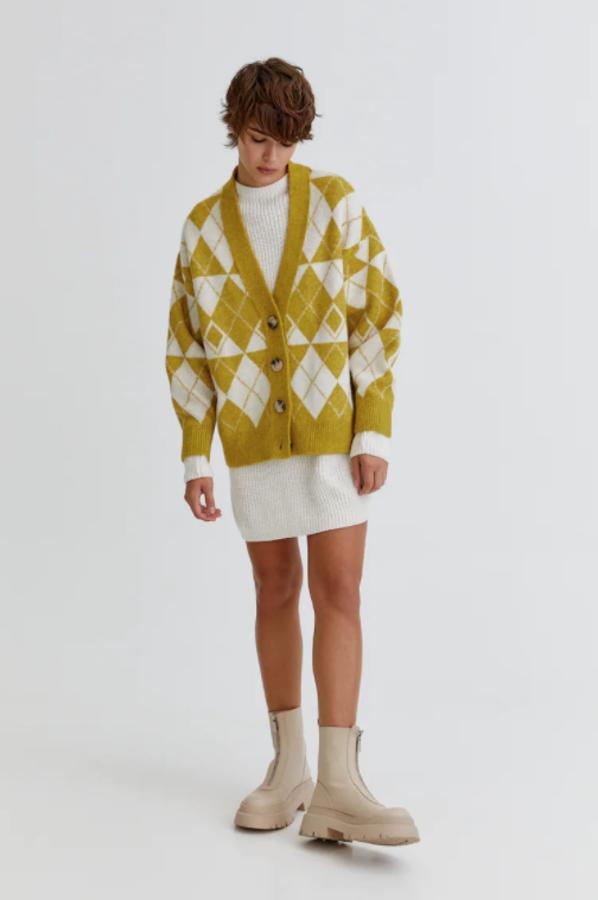 En verde oliva o verde botella, este cárdigan oversize de Pull&Bear en tejido jacquard y diseño de rombos viene con cuello de pico a contraste, cierre frontal de botones y mangas largas. Con un precio de 29,99 euros, podemos encontrarla en las tallas XS-S y M-L. 