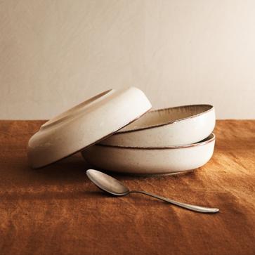 Imagen secundaria 1 - El jarrón de vidrio esmaltado cuesta 29.99 euros; la vajilla de cerámica rugosa, desde 6.99 euros los platos hondos; y la lámpara de madera y mármol, 199 euros. Todo en Zara Home