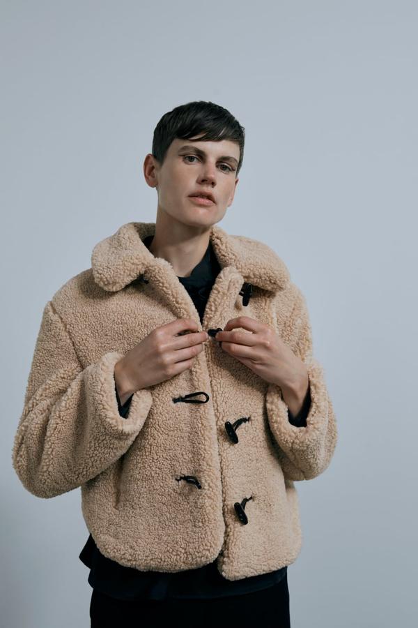 El borreguito es un tejido que resurge cada temporada con la caída de los termómetros. Esta chaqueta corta, estilo trenka, es una buena opción para llevar con pantalones de tiro alto. Chaqueta de Zara (39,99 euros). 