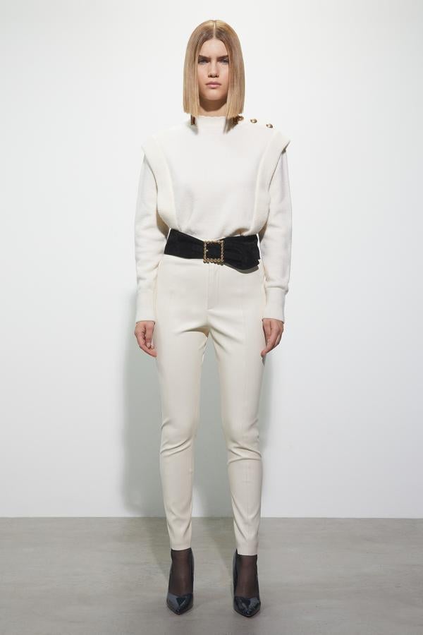 Con botones decorativos en dorado y detalle de pestañas laterales en canalé, este jersey en blanco nata con cuello y puños en canalé tiene un precio de 25,99 euros y está disponible en las tallas S, M y L.