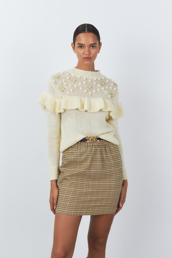 En color vainilla, con bordados en la parte superior del cuerpo y volante, este jersey con cuello caja en canalé y mangas largas acabadas en puño de canalé tiene un precio de 29,99 euros y está disponible en las tallas S, M y L. 