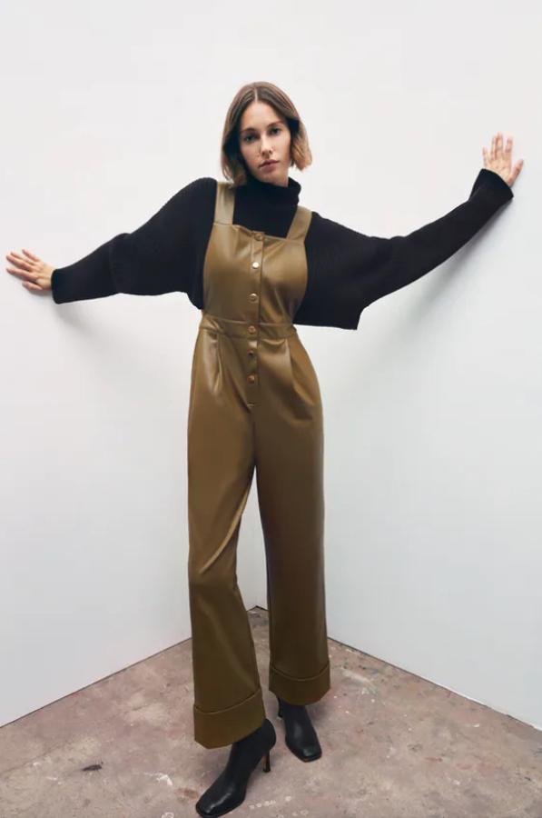 Este mono en color caqui y efecto piel de Zara viene con escote recto con tirantes anchos y bolsillos y pinzas delanteras. Con perneras rectas y bajo acabado en vuelta, tiene cierre frontal de botones a presión y cuesta 39,95 euros. Está disponible entre las tallas XS y XL.