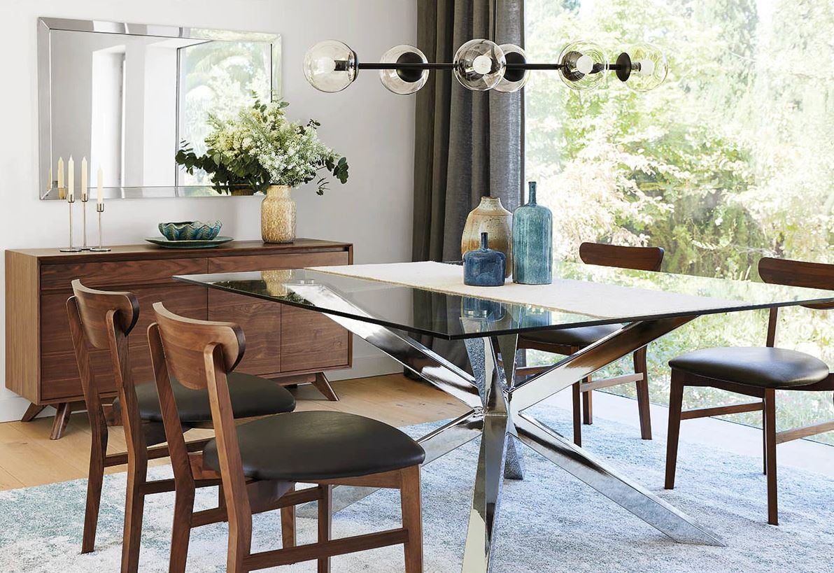 Esta mesa de comedor en cristal y acero permite pasar la luz a través de ella hasta hacerla pasar casi desapercibida. Está rebajada en El Corte Inglés y cuesta 555 euros.