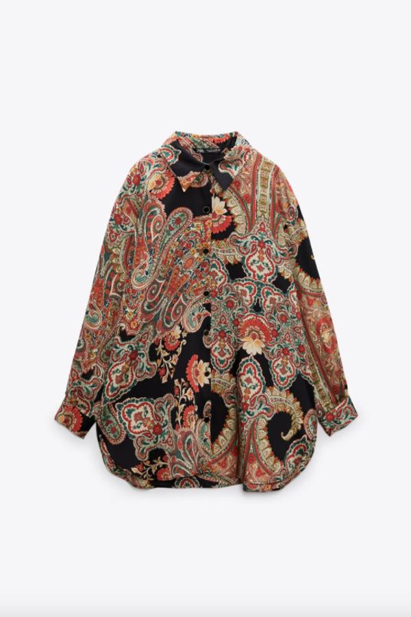 Estampado paisley en tonos rojizos y azules sobre fondo negro para esta camisa de cuello solapa con mangas largas y bajo asimétrico más largo en la espalda que tiene cierre frontal de botones y cuesta 29,95 euros. 