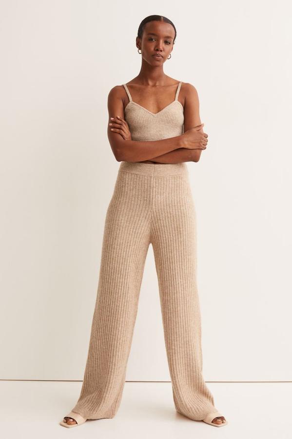 Perneras rectas amplias para este pantalón de punto de H&M de punto suave con lana en la trama y cintura estándar en punto elástico de canalé. Cuesta 19,99 euros y podemos encontrarlo en beige jaspeado, en negro y en crema entre las tallas XS y XXL. 