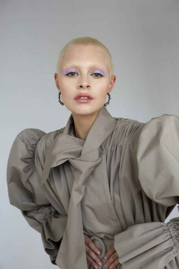 Vestido trench coat de Balenciaga y pendientes de aro, de Giovanni Raspini.