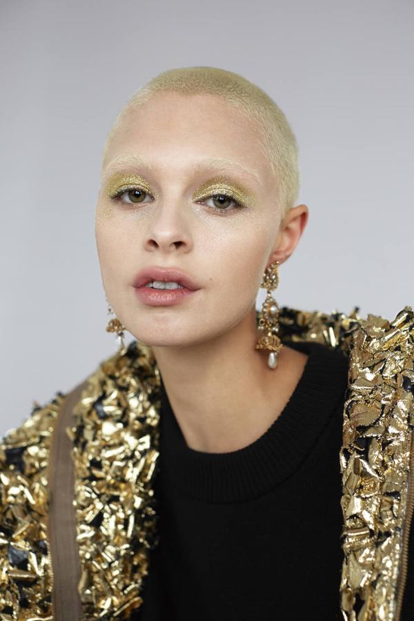 Las barras de labios en tonos fresa y los bálsamos con color ponen el contrapunto al maquillaje intenso de la mirada. Glow Fantasy, de Fenty Beauty (37 €), además, hidrata los labios. Parka metalizada y jersey sin mangas de Louis Vuitton. Los pendientes son de Pebble London.