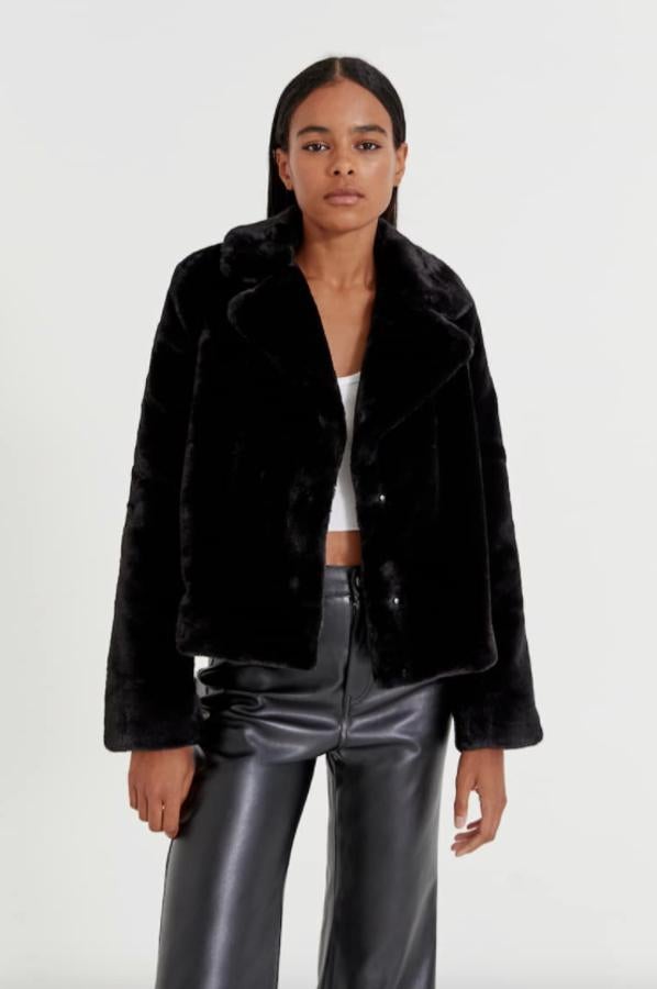 Con cuello de solapa con muesca, este abrigo corto de pelo de Pull&Bear con cierre frontal de botones y mangas largas cuesta 29,99 euros y está disponible entre las tallas XS y XL. 