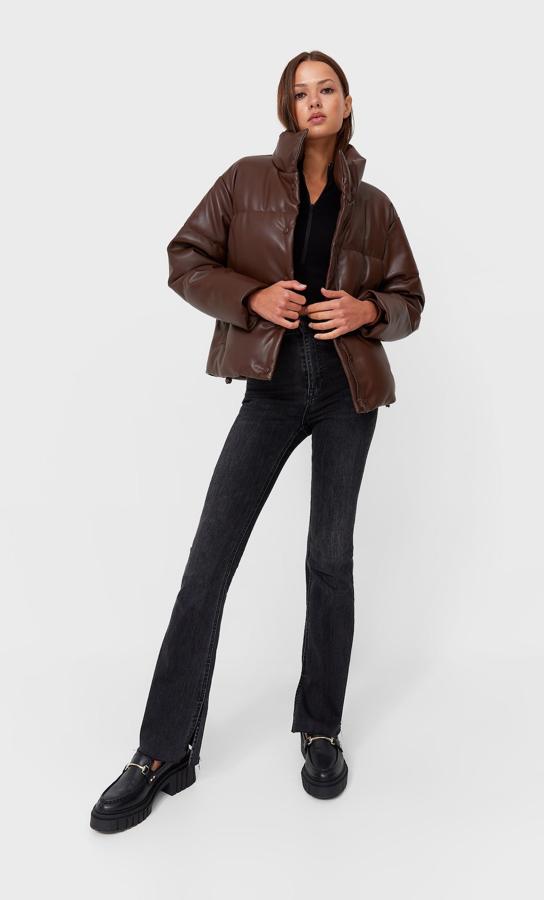 Disponible en negro, rojo, marrón y crudo, esta cazadora acolchada en efecto piel de Stradivarius con cuello altos y bolsillos laterales en forro polar tiene cierre frontal de cremallera oculta por tapeta con botones a presión cuesta 39,99 euros y está disponible entre las tallas XS y XL. 