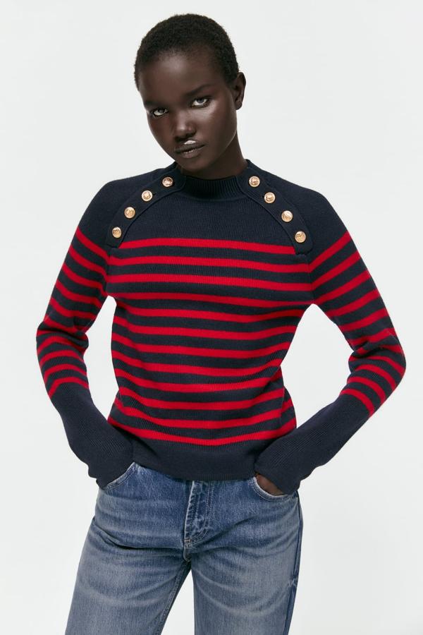 Un jersey de rayas marinero es un básico pero este diseño no es como los demás. En rojo y azul marino y con dos hileras de botones dorados. Jersey de puento con cuello alto de Zara (39,99 euros)