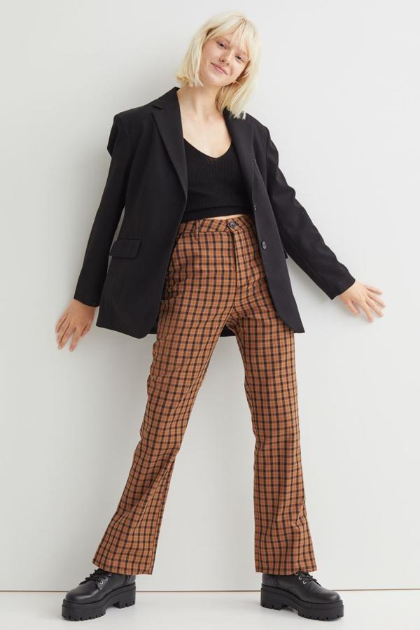 En marrón y negro, con bajos ligeramente acampanados con abertura, este pantalón con estampado de cuadros de H&M es de talle alto y viene con bolsillos al bies. Cuesta 19,99 euros y está disponible entre las tallas 32 y 50.