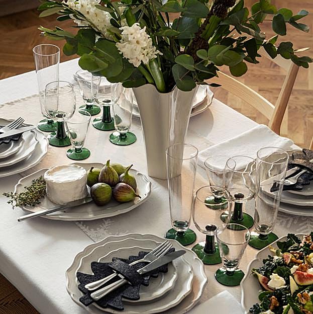 Imagen principal - El mantel de lino lavado (disponible en más colores) cuesta 49.99 euros; el plato de cerámica pintado a mano, 24.99 euros la unidad, igual que el bol.