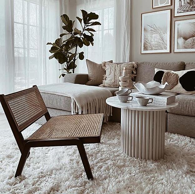 Imagen principal - El sillón bajo de ratán cuesta 149 euros en H&M Home; la silla lounge negra cuesta 79 euros y el taburete de ratán, también disponible en color madera, cuesta 49.99 euros. 