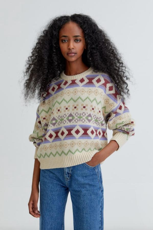 Estampado multicolor en tonos lila, verde y granate para este jersey de punto jacquard de Pull&Bear con cuello redondo y detalle de rib que tiene un precio de 25,99 euros y está disponible entre las tallas XS y XL. 