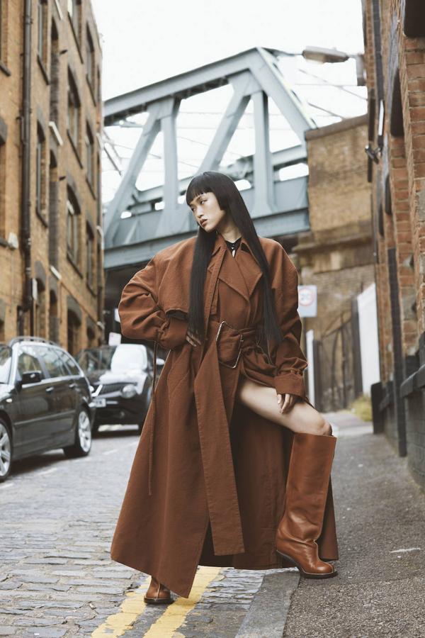 Gabardina con cinturón y botas, todo de Acne Studios; y top negro de Amlul.