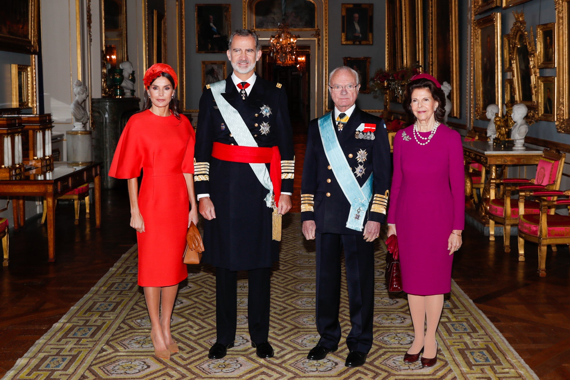 Una vez que la Reina se ha despojado de su capa con cuello de piel hemos descubierto su maravilloso vestido color coral con impresionantes mangas con volumen, un diseño de Carolina Herrera de 2015 que doña Letizia no había estrenado hasta ahora y que le sienta como un guante.
