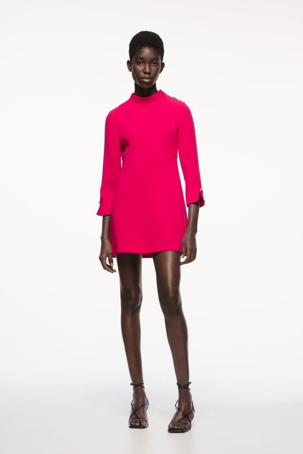 El rosa se ha convertido en el color de fiesta inesperado que siempre funciona. Este mini vestido de cuello alto es una de las opciones más favorecedoras del momento. Vestido corto en color rosa de Zara (29,99 euros). 