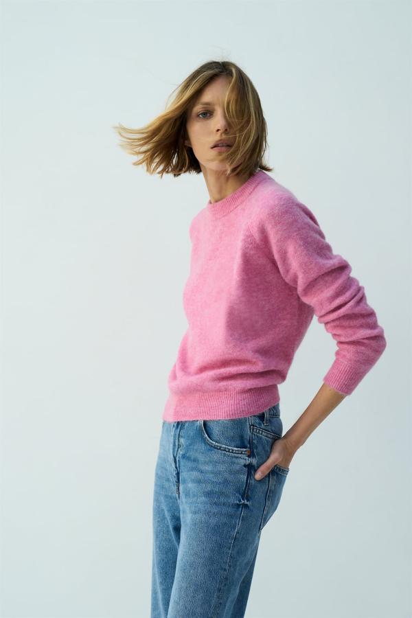 Un jersey que lo tiene todo: un bonito color rosa, una buena composición con lana y un corte de lo más favorecedor. Jersey corto de Zara (29,99 euros). 