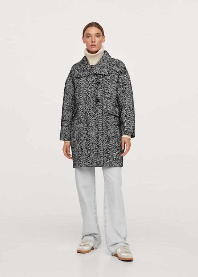 Diseño medio recto con cuello chimenea para este abrigo de espiga en blanco y negro que tiene dos bolsillos laterales de solapa y cierre de dos botones a contraste. Disponible entre las tallas XXS y XL, cuesta 89,99 euros. 