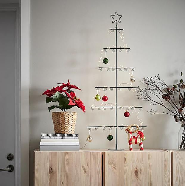 Imagen principal - Este original árbol de Navidad minimalista de IKEa cuesta 13 euros, el pack de 20 bolas de Navidad cuesta 9 euros y la guirnalda de luces con estrellas, 10 euros.