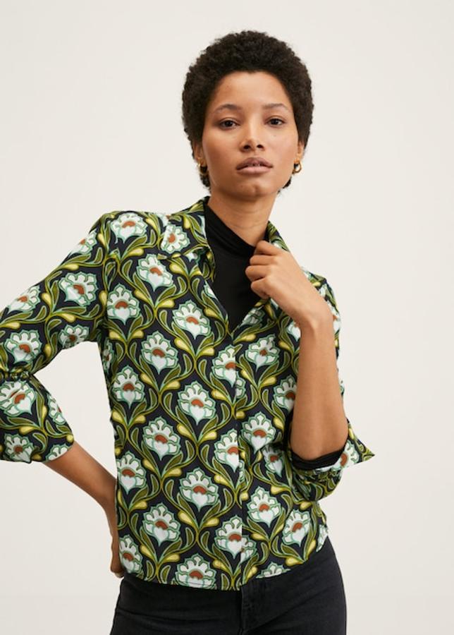 Estampado de flores en tonos verdes y blancos sobre fondo negro para esta camisa de diseño recto y cuello camisero de Mango que viene con mangas largas abotonadas y cuesta 29,99 euros. 