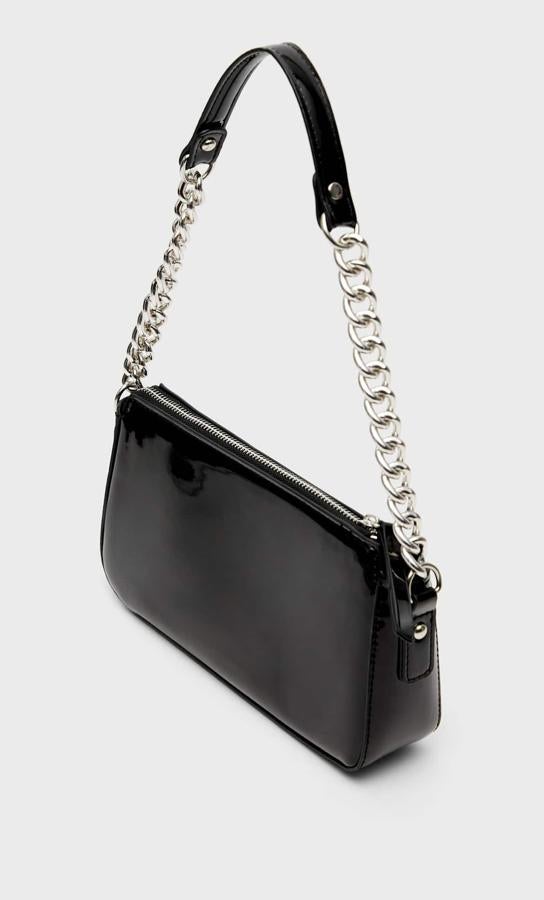 En charol y formato baguette, con asa de mano en cadena y asa de hombro a tono, esta bandolera de Stradivarius cuesta 15,99 euros. 