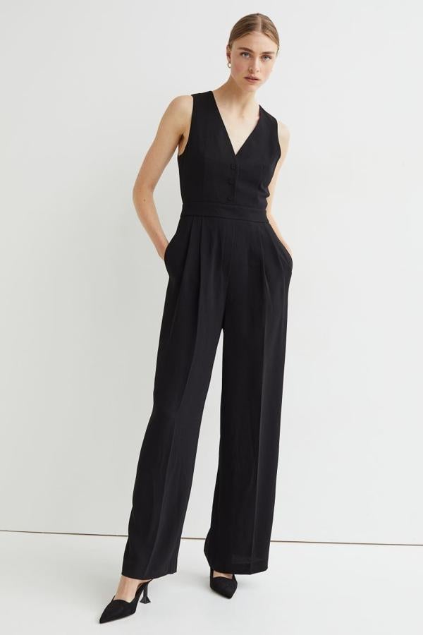 De venta exclusiva en la web de H&M, este mono negro sin mangas, con escote de pico, botones frontales revestidos y perneras amplias con raya tiene un precio de 49,99 euros. 