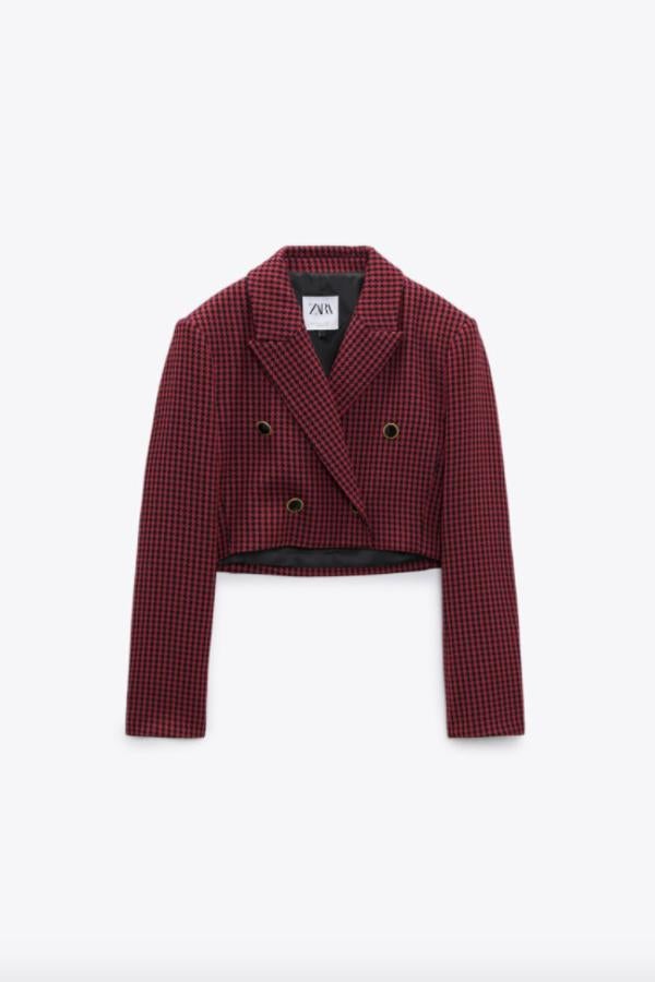 En color rojo con estampado pata de gallo en negro para esta blazer cropped con cuello de solapa y escote de pico cruzado. Con mangas largas con hombreras y cierre frontal cruzado con botones en negro y detalles dorados, podemos comprarla por 39,95 euros. 