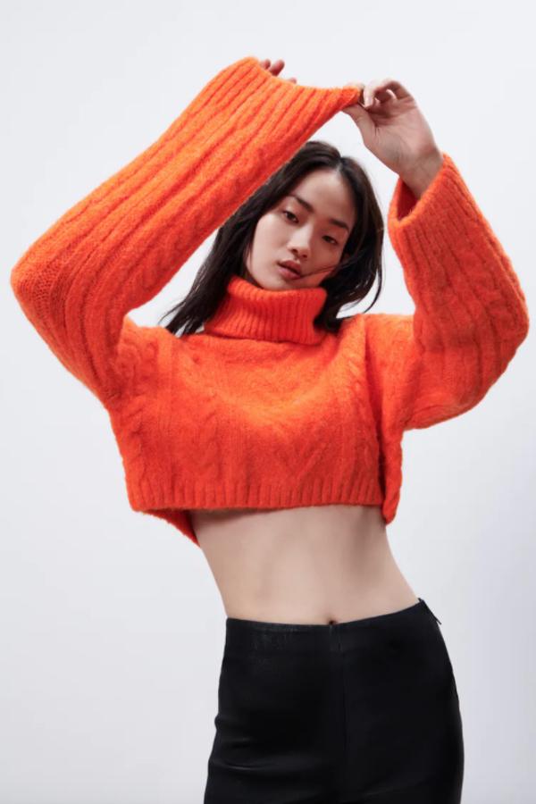 Diseño cropped y cuello subido para este jersey de punto en color naranja que viene con mangas largas y podemos encontrar en Zara por 25,95 euros. 