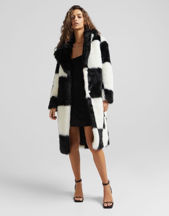 Con cuello de solapa, cierres de snaps ocultos y diseño midi, este abrigo de pelo de Bershka tiene un precio de 79,99 euros. 