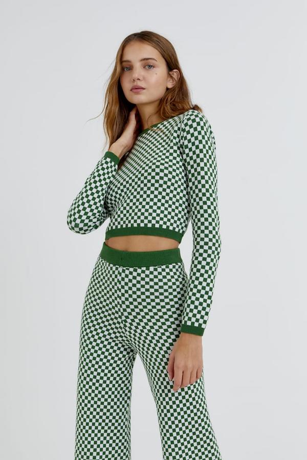 A juego con el pantalón, Pull&Bear ha lanzado este jersey en punto jacquard con estampado damero en verde o en marrón. Con cuello redondo, diseño cropped y mangas largas, tiene un precio de 19,99 euros. 