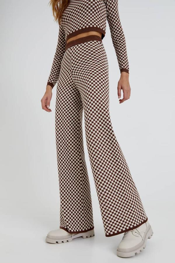 En verde y blanco, o en marrón y blanco, este pantalón jacquard con estampado damero y perneras ligeramente acampanadas solo se puede comprar en la tienda online de Pull&Bear y cuesta 25,99 euros. 