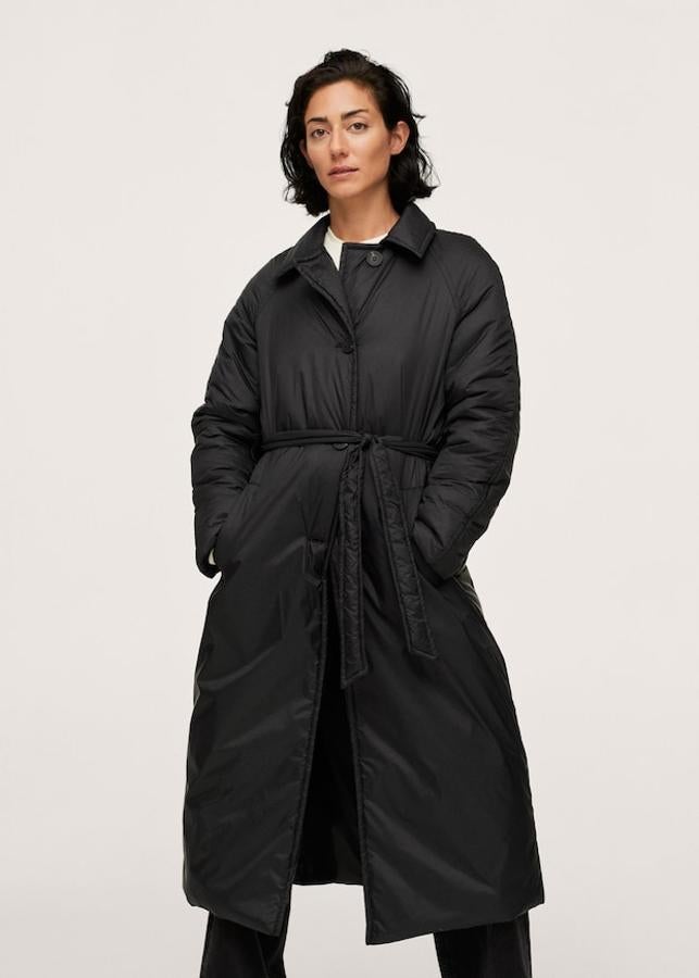 De venta exclusiva en la web de Mango, este abrigo negro de diseño acolchado largo y recto viene con cuello clásico, mangas largas y cinturón ajustable a tono. Con bolsillos laterales y relleno, tiene cierre de botones frontal y cuesta 99,99 euros. 