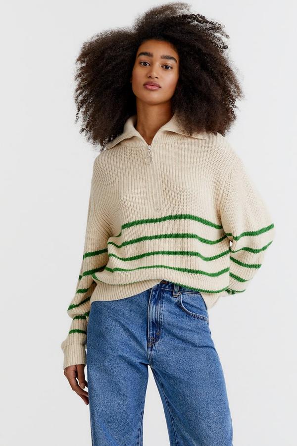 En color crema, con cuello alto y cremallera hasta el pecho, este jersey de punto con rayas verdes es de Pull&Bear y tiene un precio de 29,99 euros