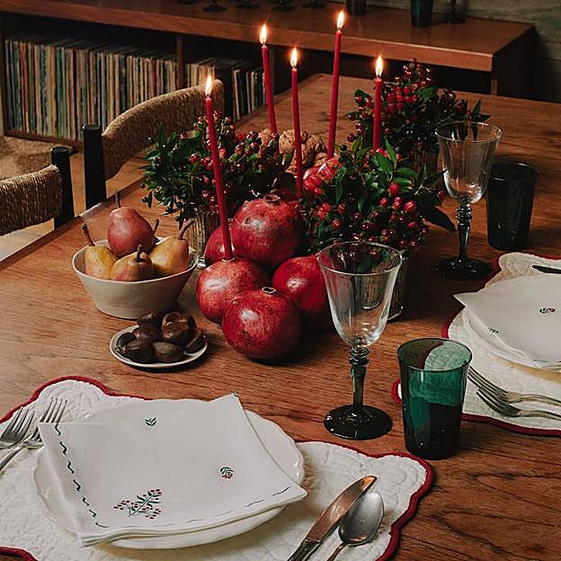 Imagen principal - El mantel de lino con cenefa estampada cuesta 59.99 euros y las servilletas, 12.99 euros. Los platos cuestan 4.99 euros la unidad, igual que los cubiertos, y las copas con base de color, 4.99 euros. Las sillas cuestan 129 euros cada una.