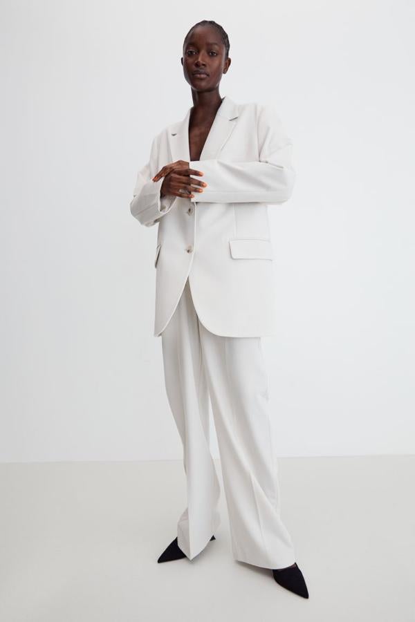 Diseño oversize para esta americana de H&M que podemos encontrar en beige, blanco, rosa de antaño y verde. Con solapas de muesca, bolsillos delanteros ribeteados con solapa y un bolsillo en la pechera decorativo, tiene cierre de botonadura frontal a tono y cuesta 39,99 euros. 