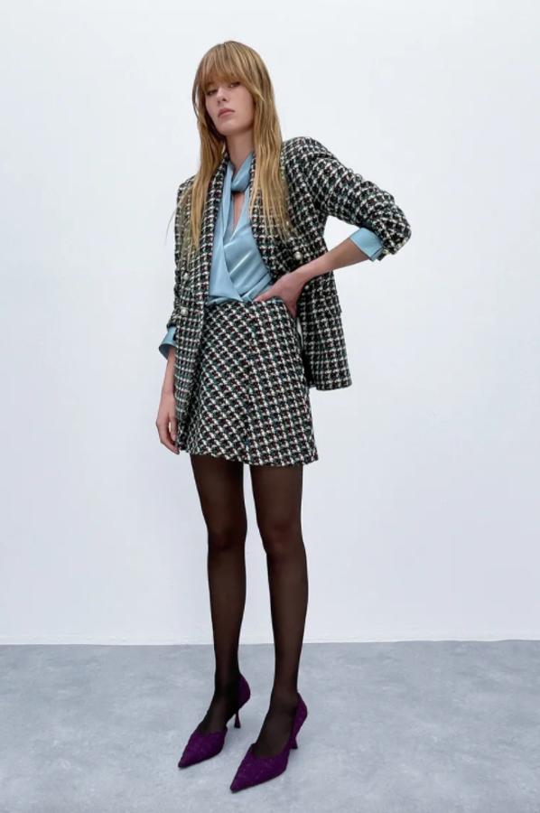 Estampado de cuadros en tonos negros, verdes, rojos y blancos para esta blazer con cuello solapa y cierre frontal cruzado con botones en aplicación perla. Tiene bolsillos delanteros de solapa, cuesta 49,95 euros y es de Zara.