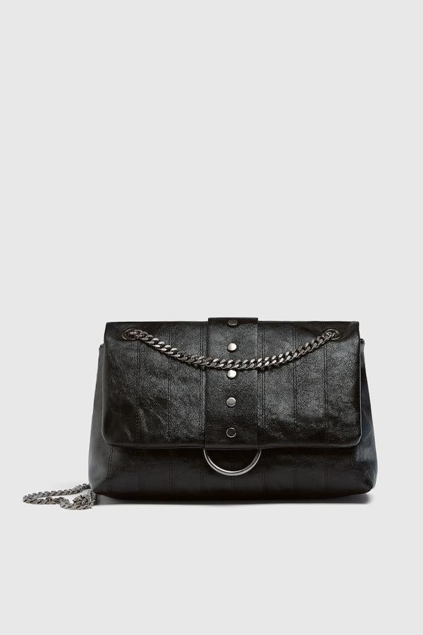 Con detalles de pespuntes y metalizados en la solapa, esta bandolera negra de Pull&Bear con cierre de solapa e imán y asa larga de hombro con cadena cuesta actualmente 25,99 euros. 