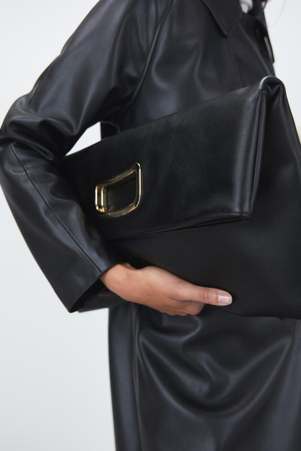 Con asa dorada integrada en el cuerpo y dos posiciones, ambas de mano, este bolso negro de Sfera con cierre de imán cuesta 25,99 euros.