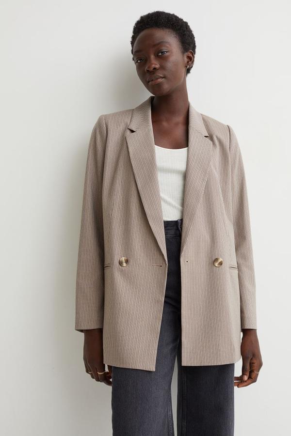 Estampado de cuadros micro en negro para esta americana en beige oscuro que es de corte recto, tiene cierre de doble botonadura y solapas de muesca. Podemos comprarla por 29,99 euros. 