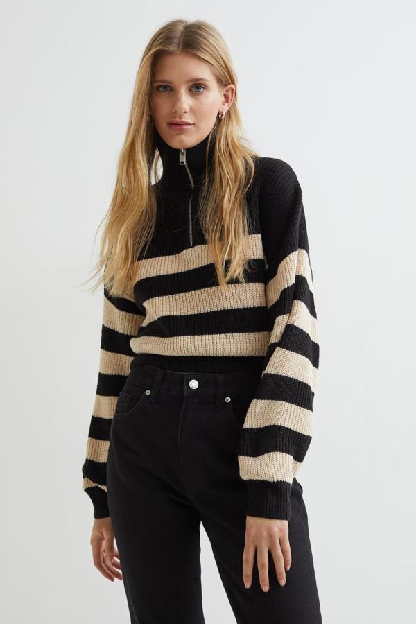 Disponible en negro con rayas beige o con rayas mostaza, o en blanco con rayas azules, este jersey que se vende exclusivamente en la web de la firma es de diseño cropped y viene con media cremallera en el escote y diseño de hombros caídos. Confeccionado en punto de canalé suave, tiene un precio de 24,99 euros. 
