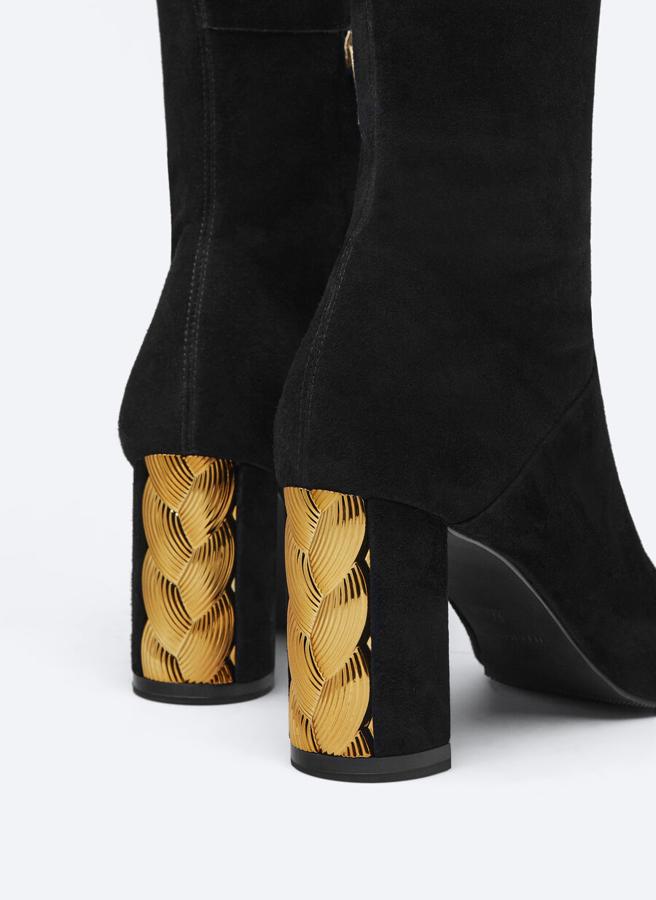 Estas botas altas en color negro con caña de 32 centímetros y tacón de 8 que viene con detalle de adorno incrustado en dorado acaban en punta y tienen cremallera corta interior. Disponible entre los números 35 y 41, cuestan 169 euros. 