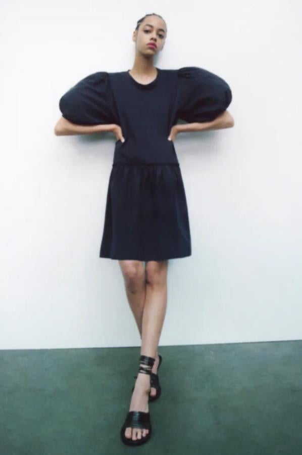 Diseño corto con cuello redondo y mangas abullonadas para este vestido de Zara en azul marino con detalle de aplicación de tejido combinado a tono y bajo acabado en volante que costaba 19,95 euros yu ahora podemos comprar por 9,99 euros.