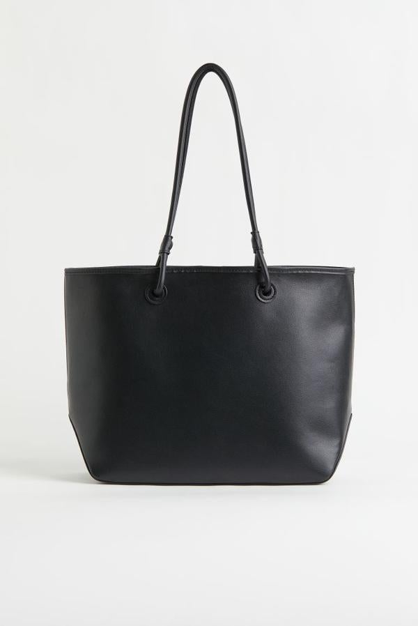 De venta exclusiva en la web de H&M, este bolso negro con doble asa de hombro y confeccionado en piel sintética cuesta 19,99 euros.