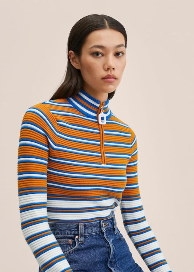 Diseño de rayas en blanco, azul y naranja para este jersey de punto elástico, diseño recto y cuello perkins con cremallera en el escote que cuesta 39,99 euros. 