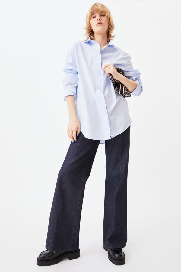 En azul celeste, blanco o rosa con rayas blancas, esta camisa oversize de algodón que podemos encontrar en el catálogo de H&M viene con cuello clásico, botonadura frontal y diseño de hombros caídos. Tiene un bolsillo de plastrón en la pechera y bajos ligeramente redondeados y cuesta 19,99 euros. Podemos encontrarla entre las tallas XS y XXL. 