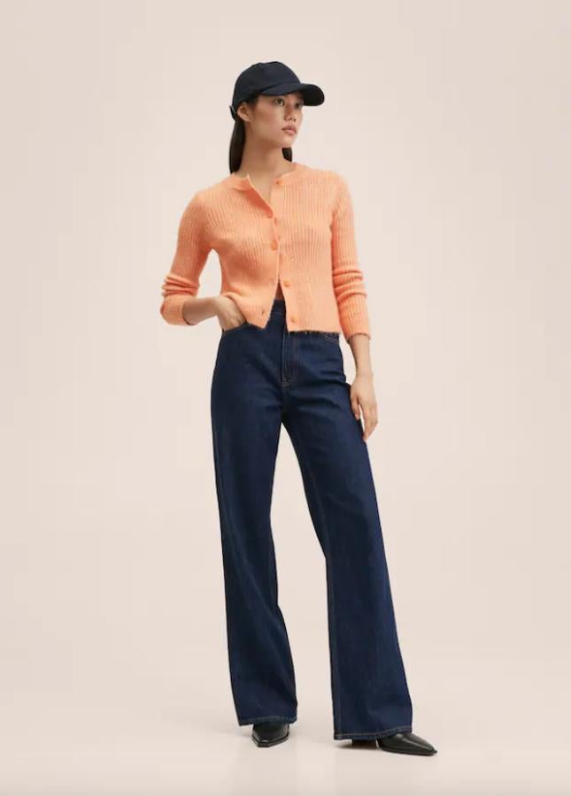 Confeccionado en punto de canalé y color mandarina, este cárdigan de diseño recto cropped, con cuello redondo y cierre frontal de botones a tono tiene un precio de 25,99 euros y solo se vende en la tienda online. 