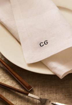 Imagen secundaria 2 - El mantel de lino con estampado de rayas en tonos tierra cuesta 25.99 euros en Zara Home. La vajilla de loza pintada, desde 4.99 euros la pieza, el mismo precio de las servilletas bordadas personalizadas.